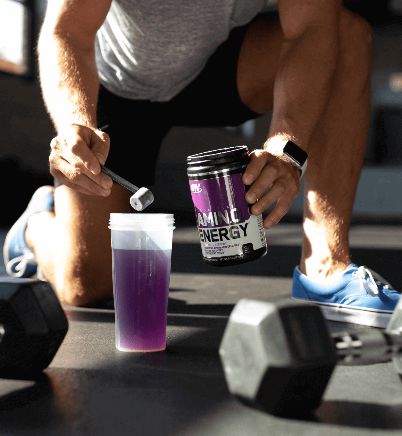 Man in gym adding Amino Energy to his shaker cup.