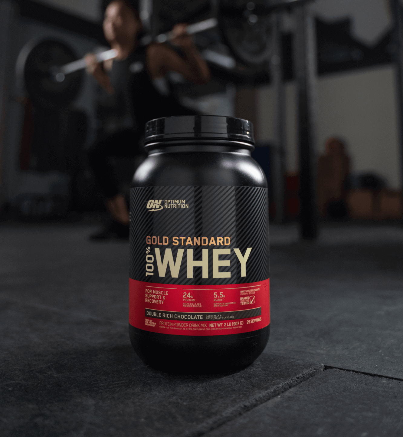 Man training with a bottle of Gold Standard 100% Whey nearby