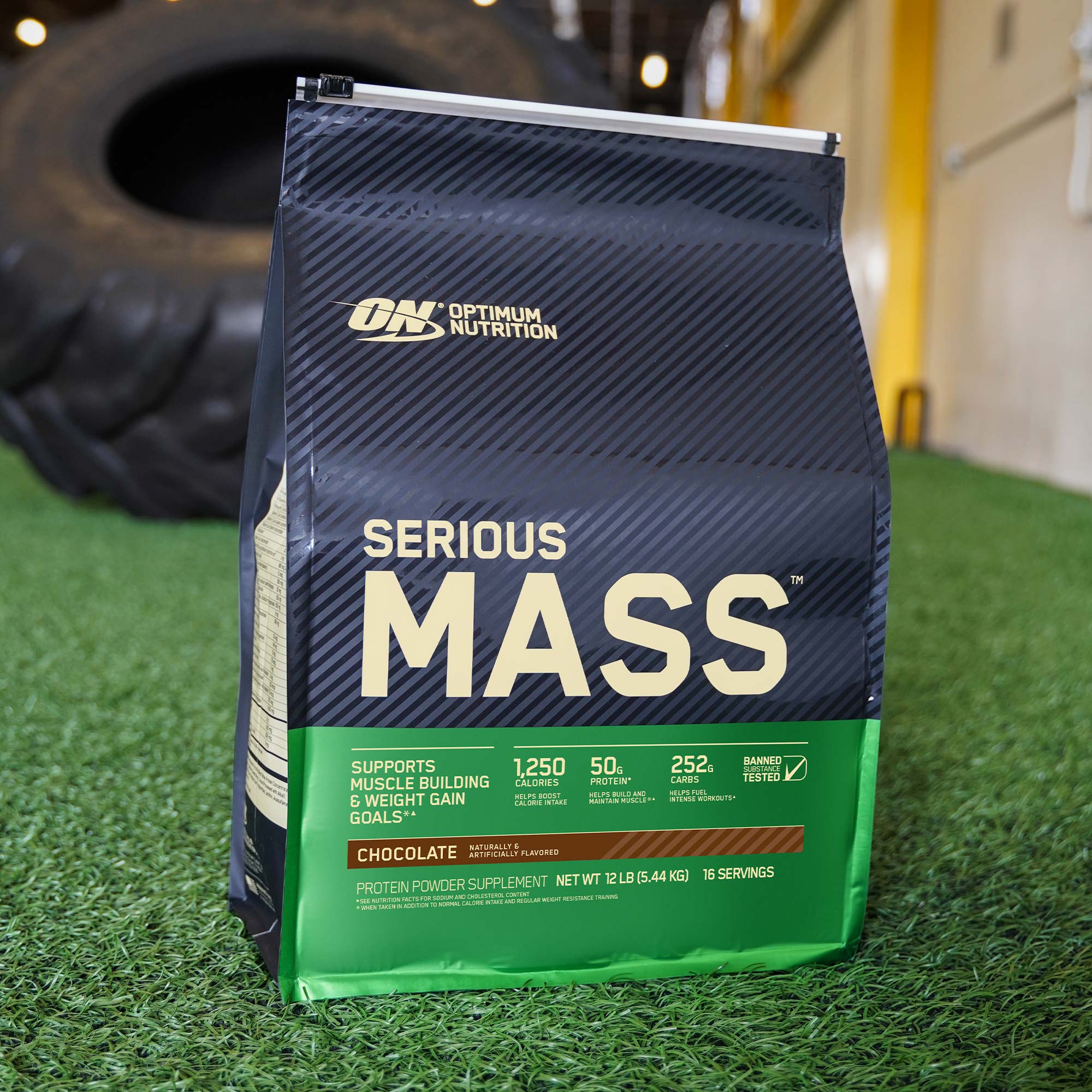 a pouch of optimum nutrition serious mass on astroturf pitch