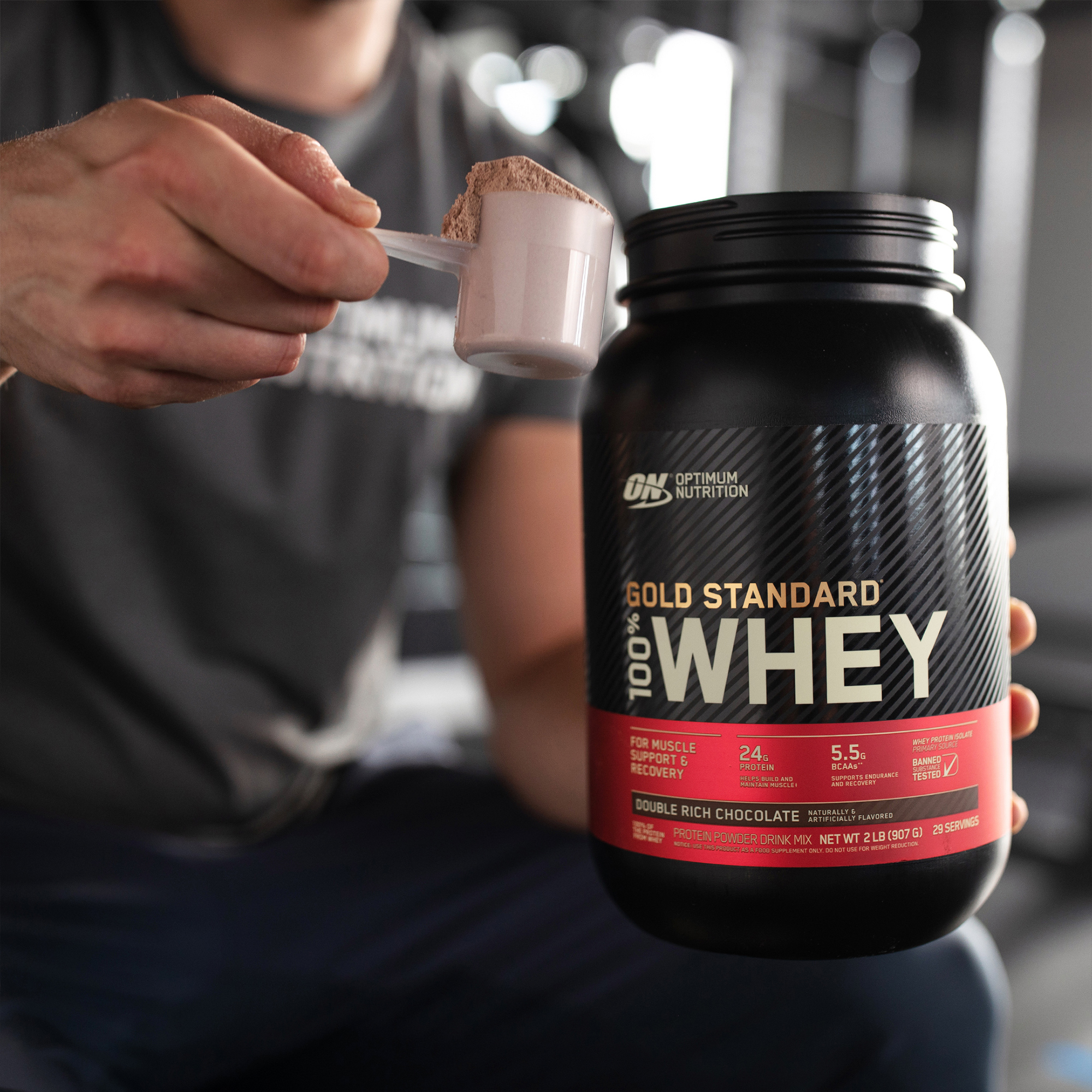 tub of optimum nutrition gold standard 100% whey with man in background